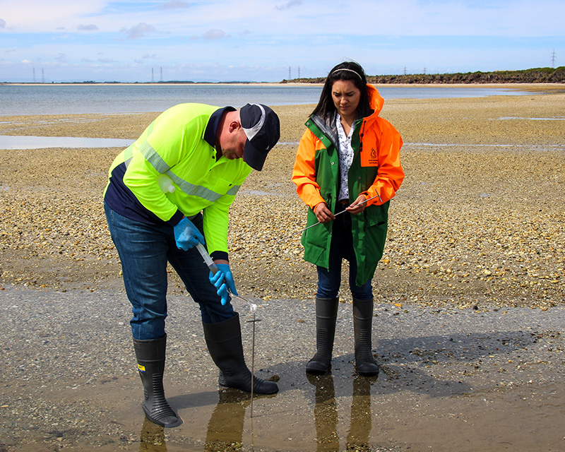 ​Warren from EHS is assisted by Andrea our Tiwai consents liaison Lead to collect a sample of porewater.